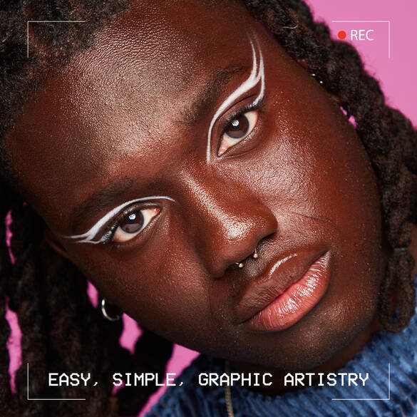 Close-up of a person with dark skin and bold white graphic eyeliner against a pink background, showcasing artistic expression.