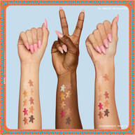 Features three arms with diverse skin tones, each displaying swatches of the eyeshadows from the NYX Professional Makeup Holiday Gingerbaddie Palette, illustrating how the colors appear on different complexions.